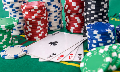 Gambling concept. Four aces combination with poker chips on green table