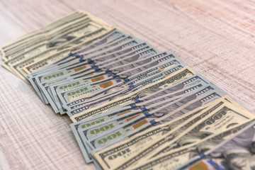 Dollar banknotes in fan on wooden table close up