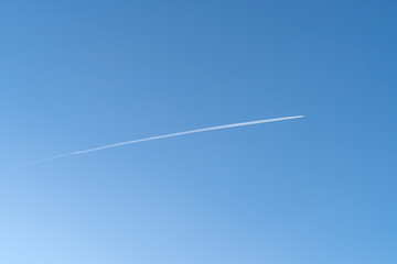 Vapor trail behind flying airplane