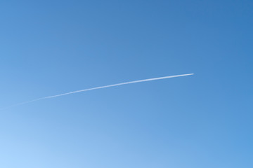Vapor trail behind flying airplane