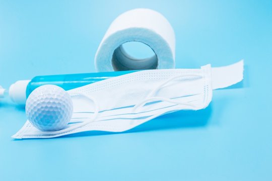 Golf ball face mask and tissue paper are on blue background - Powered by Adobe