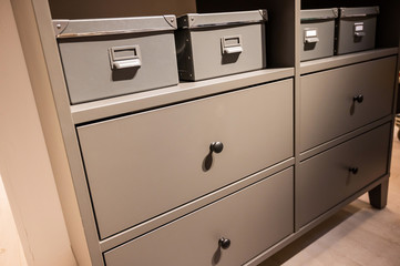 Closeup of a gray chest of drawers. A variant of simple furniture without decor and design in the interior.