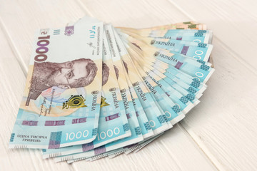 different ukraine money lying on wooden desk. UAH.