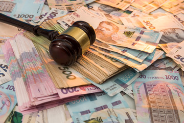 wooden hammer on ukraine money as background. 500 and 1000 new uah grivna