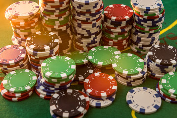 Many different cost poker chips on play table. large game bet on the green cloth field