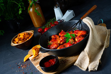 Spicy chicken wings in honey with potato wedges