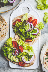 Homemade flatbread with fresh vegetables, top view. Healthy vegan food concept.
