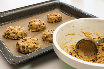 Chocolate chip cookies xlose up on a parchment-lined baking sheet