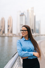 Fototapeta premium Portrait of a successful business woman in glasses smiling in an urban setting