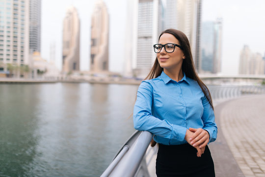 Portrait of a successful business woman in glasses smiling in an urban setting
