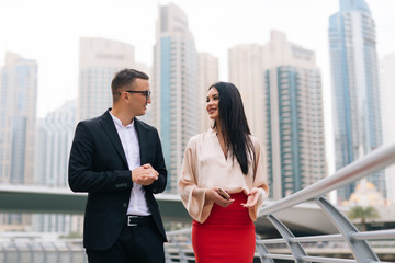 Business man and business woman are walking the streets of city.