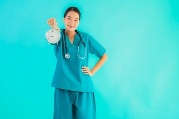 Portriat beautiful young asian doctor woman show clock or alarm
