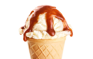 Vanilla ice cream with caramel topping on white background.