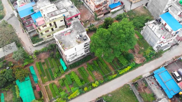 Flying over housing settlements in a small developing city Hetauda Town, Makwanpur, Nepal. Drone aerial shot birdeye view looking down. Low movement. Less people on roads.