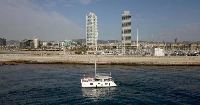 Aerial Pedestal down Sailboat front of Port Olimpic Mapfre tower background