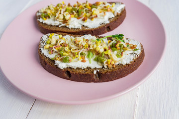 Healthy macrobiotic breakfast. Sandwich with cream cheese, peas microgreens and sprouted mung beans, walnut, sunflower and flax. vegan, raw food diet.