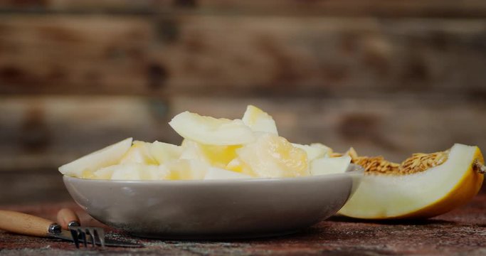 Pieces of fragrant ripe melon on the plate slowly rotated.