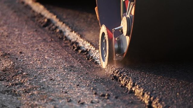 The paver mover on a flat newly made road, ramming and leveling. Asphalt paver applying asphalt on the repaired city road