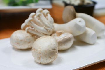 Various mushroom cooking ingredients on a white plate.