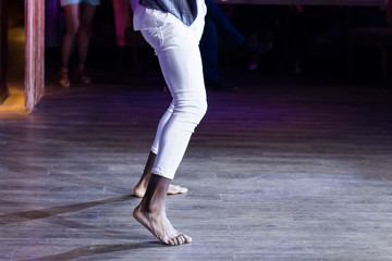 Dancing shoes feet and legs of male ballroom and latin salsa dancer dance teacher on the stage. Social dance, bachata solo and kizomba concept