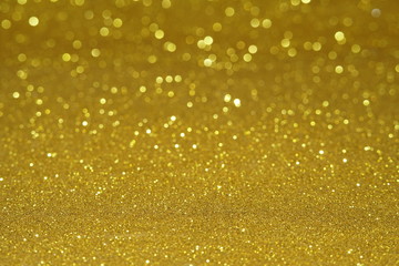 gold Sparkling Lights Festive background with texture. Abstract Christmas twinkled bright bokeh defocused and Falling stars. Winter Card or invitation	