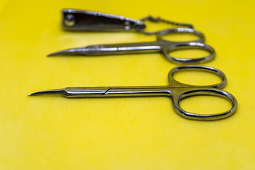 Manicure tools on yellow background, spa salon equipment concept, scissors and nail clippers - Image