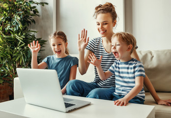Happy mother with kids having video call on laptop