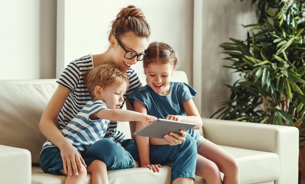 Happy woman with kids using tablet at home.