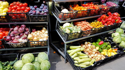 A variety of vegetables and fruits lying on a market counter for sale by a customer. Trade in agricultural products. Nitrates and pesticides. Genetically modified food. Farm fruits. Fiber and vitamins