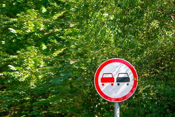 no overtaking sign on a background of trees on asummer day