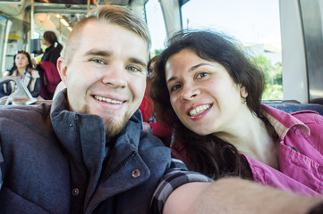 Young couple on vacation in Europe on the train take photo selfie.