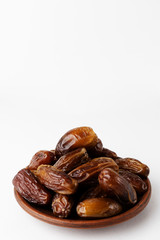 Dates on a clay plate on a white background. Vertical orientation