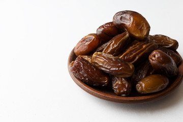 Dates on a clay plate on a white background