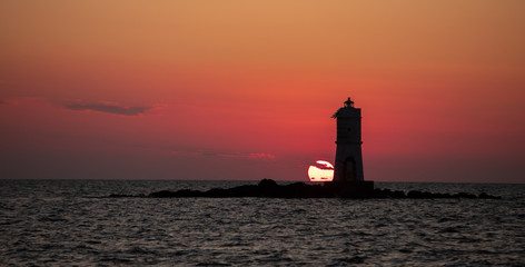  The Mangiabarche lighthouse wrapped in the waves of a mistral wind storm in a beautiful sunset