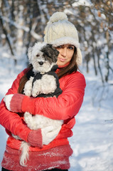 Beautiful Woman Hugging  Her Cute Dog in the Winter Forest.Pet and Owner Outdoor