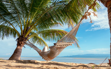 Relaxed woman swinging in a hammock at sand beach of Thailand