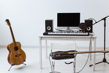 Microphone, computer and musical equipment guitars and piano background. Home recording studio...