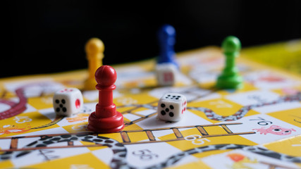 Close-up of snakes and ladders game children playground. © Wanisa