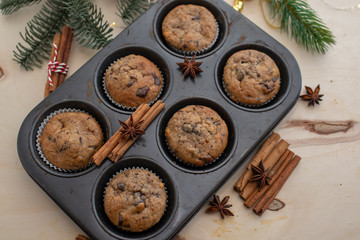 fresh chocolate muffins in muffin tin on wooden surface