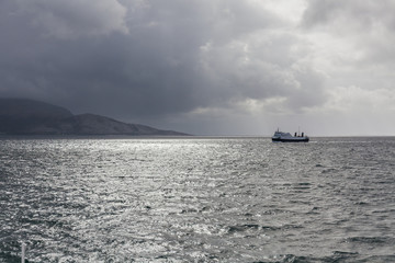 ship to visit fjords in Norway in polar day, midnight sun. A mystical fjord with dark clouds in Norway with mountains and fog hanging over the water