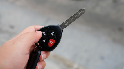 Close-up hand presses on the remote control car alarm systems.