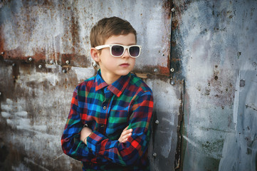 Portrait of a fashionable boy in sunglasses . A child in everyday clothes .