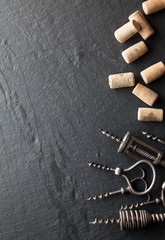 Corkscrews and corks on a dark background.
