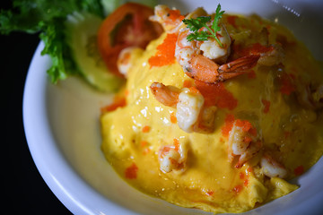 Close up Creamy Omelette with shrimp on steamed rice In a white circular dish