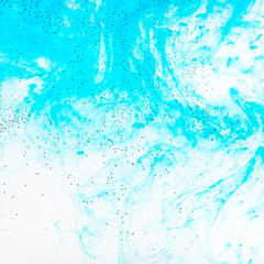 air bubbles on glass surface of flat bottle and aquamarine watercolours flow in water on background