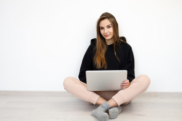 freelancer girl woman in sweater sitting on the floor with laptop computer, concept online education, work from home