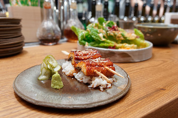 Fried unagi eel with barbecue sauce on bar counter