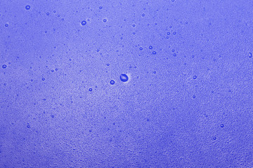 drops of water dripping close on a blue background.