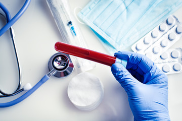 The epidemic of coronavirus. Hand of a doctor holding a bottle of blood sample.
