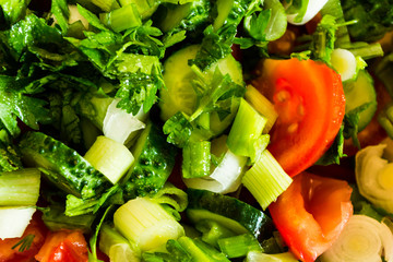 Fresh salad with tomatoes, lettuce, onion, cucumbers and parsley.
